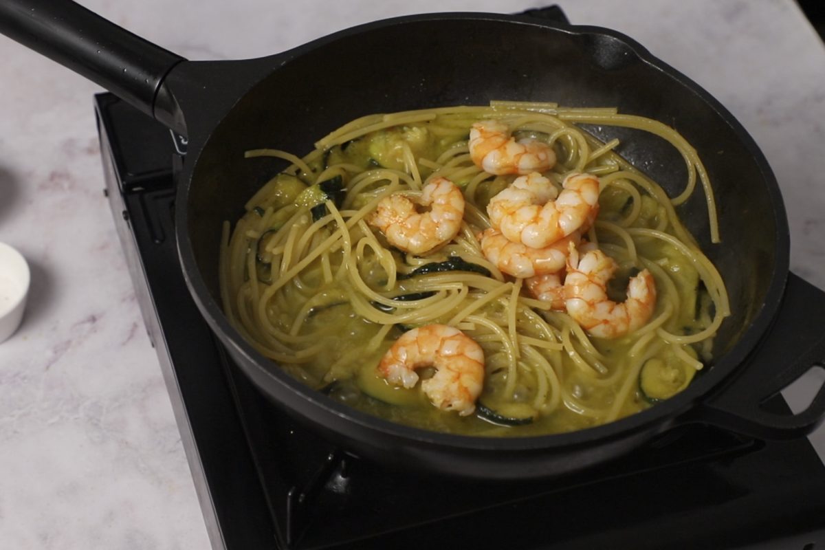 Espaguetis con langostinos. Integramos la pasta con el resto de ingredientes.