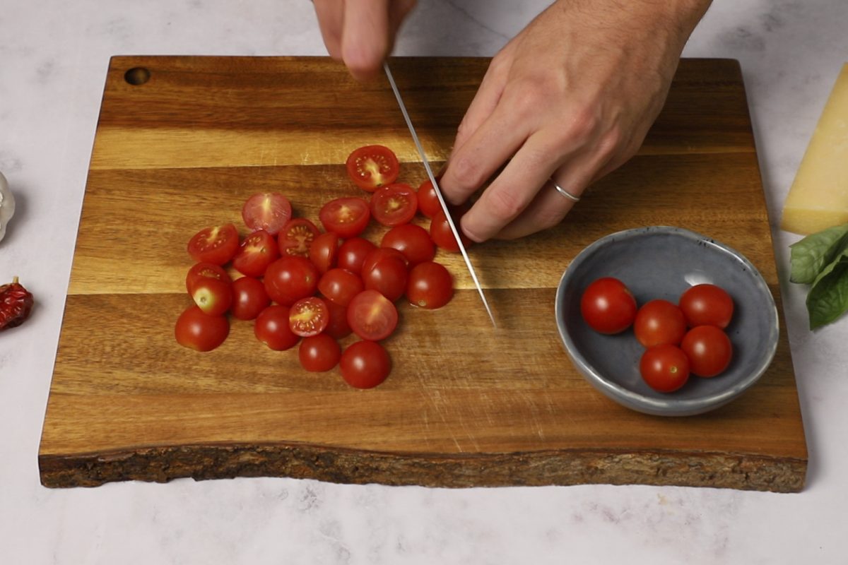 Pasta al horno. Cortamos butifarra y tomates cherry.