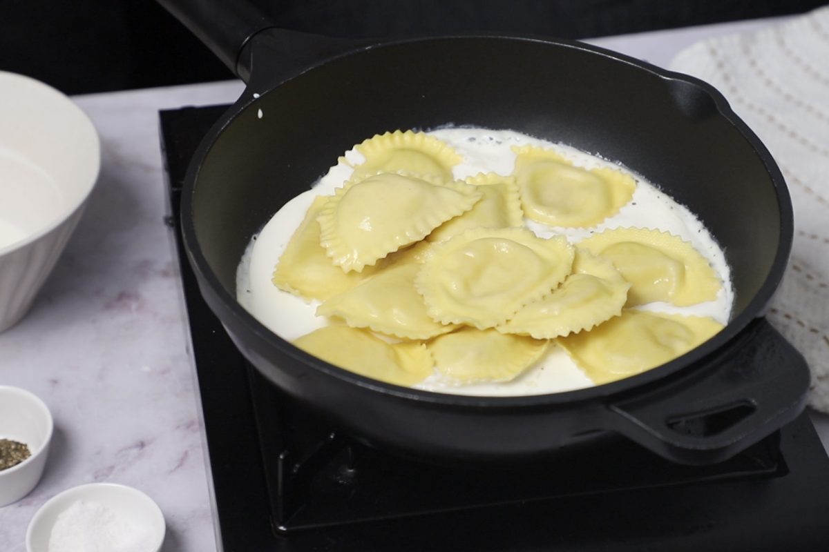 Receta de Raviolis con nata. Incorporamos la pasta cocida a la sartén.